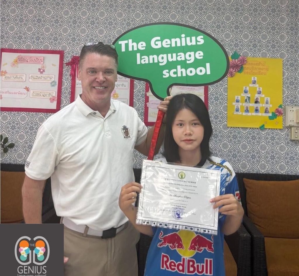 The Genius Language School - August - A student with her certificate posing with a head or teacher holding a placard