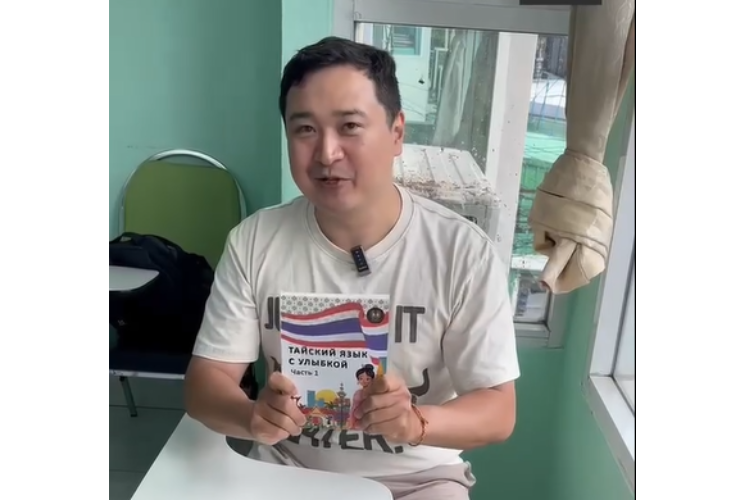 Man holding a Thai Language Coursebook for Russian speakers