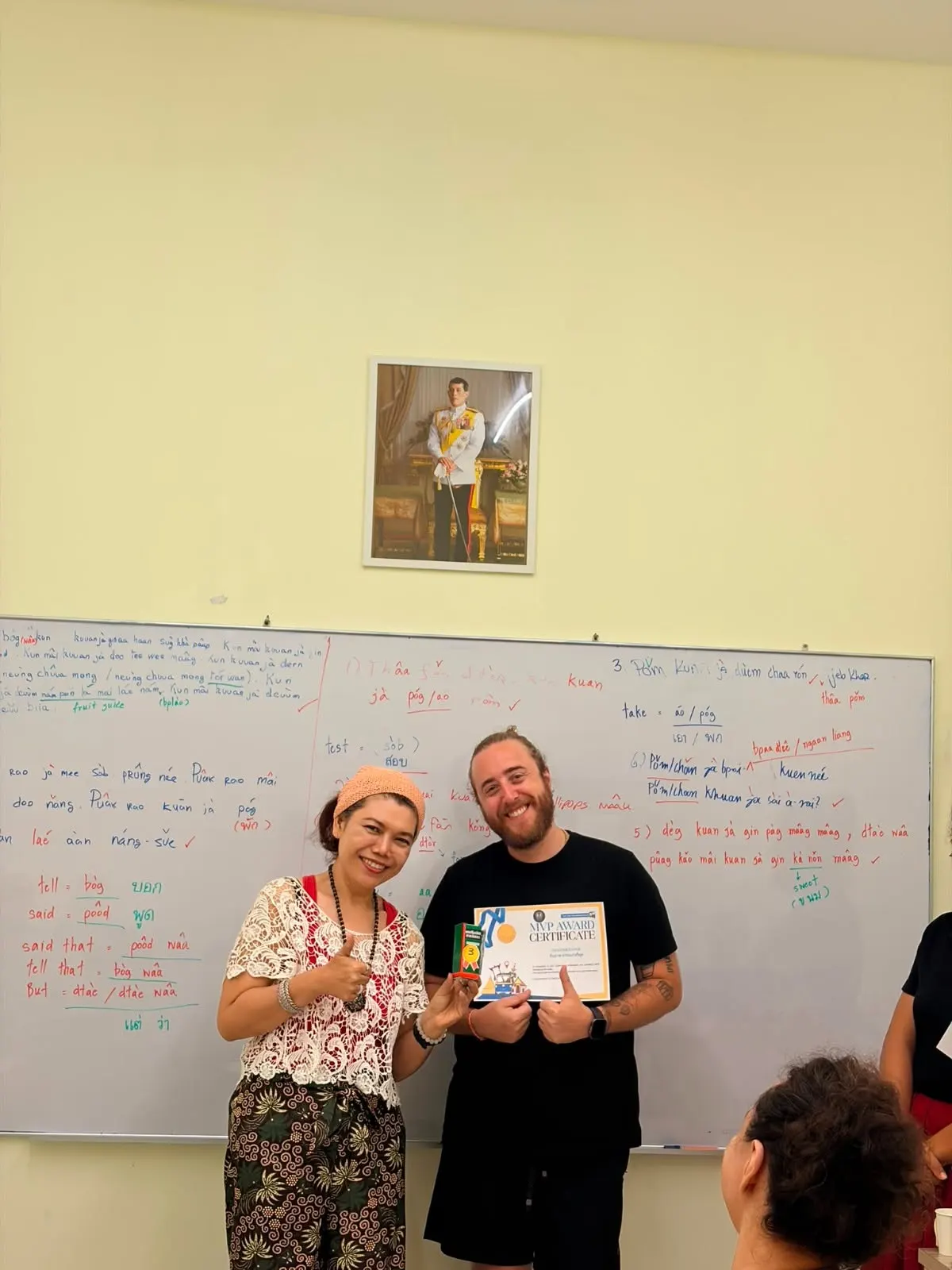 Teacher handing language training completion certificate - Genius Language School Chalong